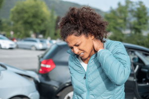 a woman rubbing her neck after suffering an injury in a car accident 