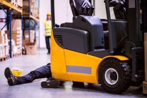 A forklift in a warehouse running over a worker