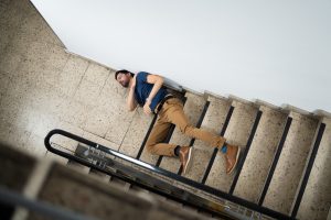 A man with fractured or broken bones at the bottom of a staircase. 