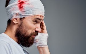 A man with a bloody bandage wrapped around his head.